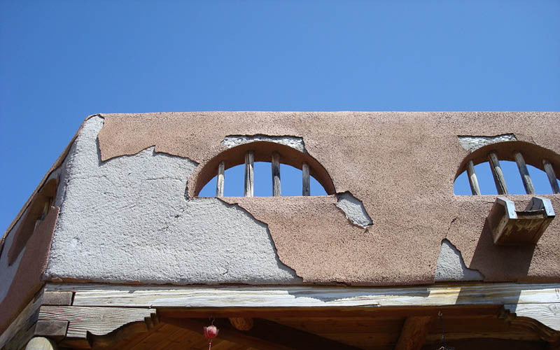 Cracked stucco on a flat-roofed home parapet