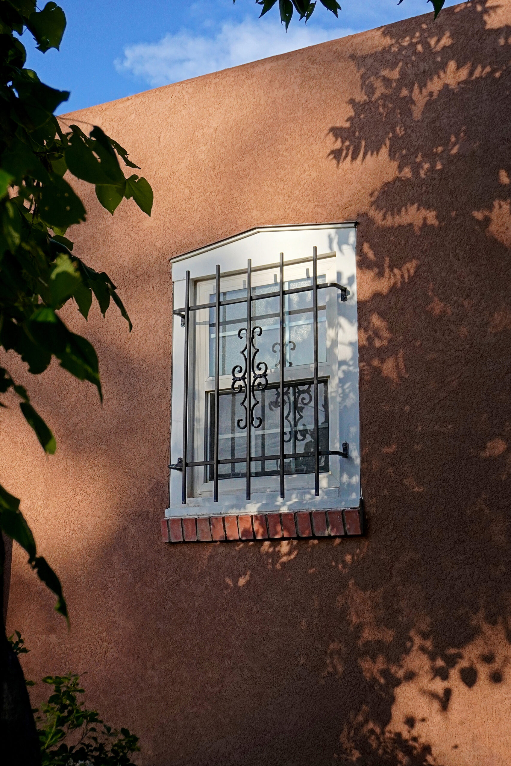 A historic home in Albuquerque Nob Hill with an antique window and wrought iron details.
