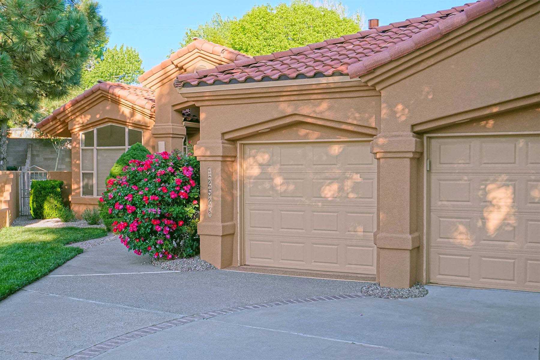 Home in north-east Albuquerque with newly redone tan stucco and a two-car garage